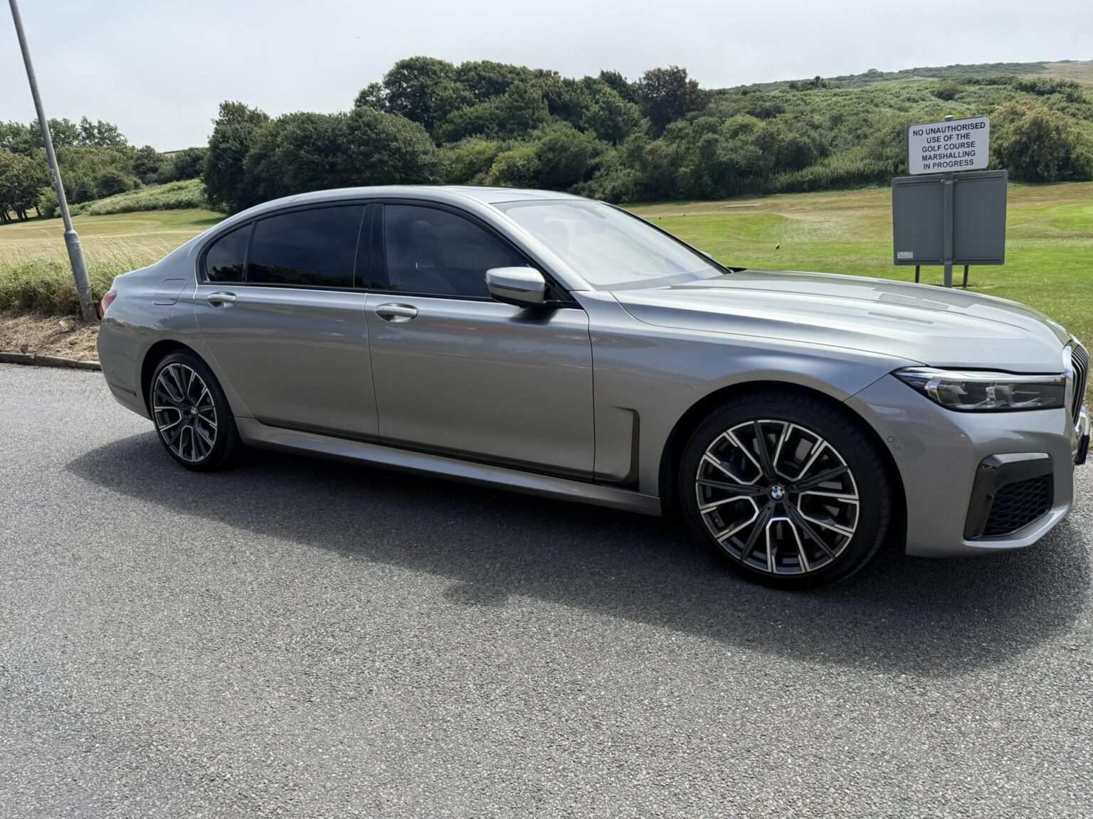 Grey BMW 7 Series chauffeur car on a coast road in Sussex