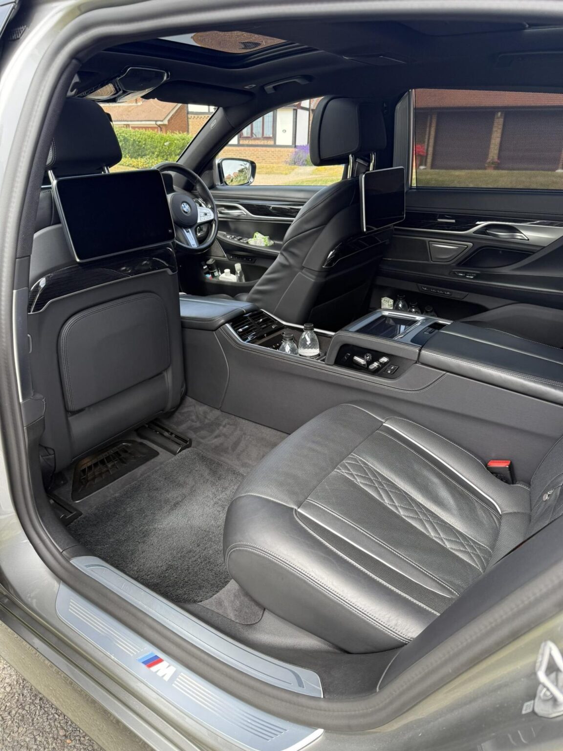 Rear door of a BMW 7 Series open, showing the back seat