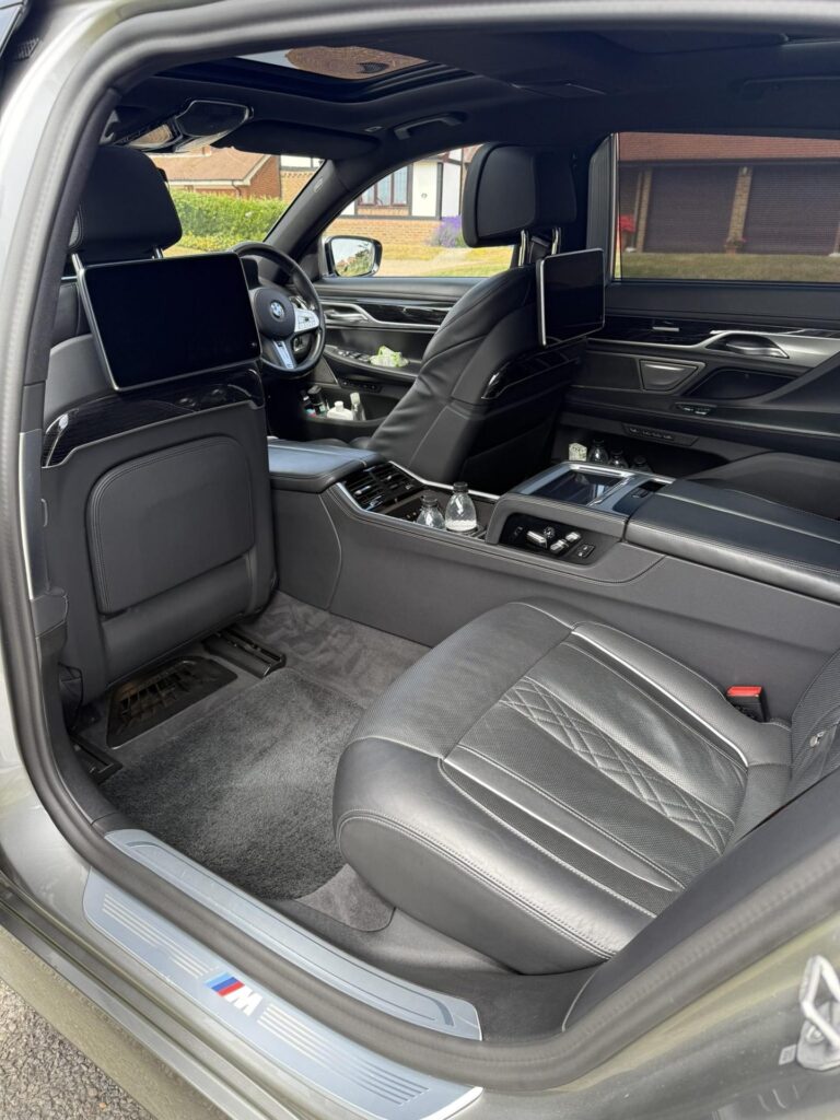 Rear door of a BMW 7 Series open, showing the back seat