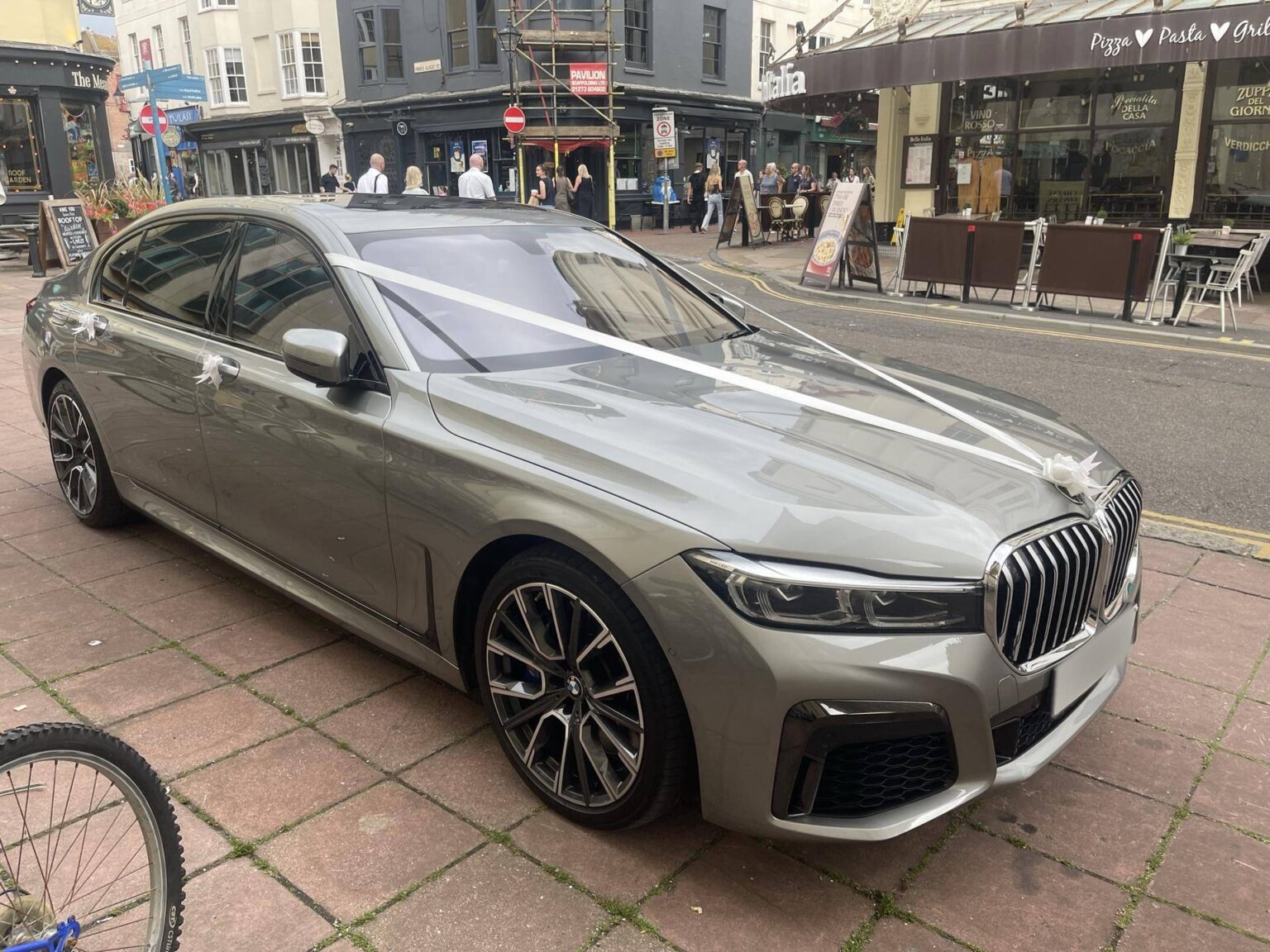 BMW 7 Series wedding car with white ribbons on a Brighton street